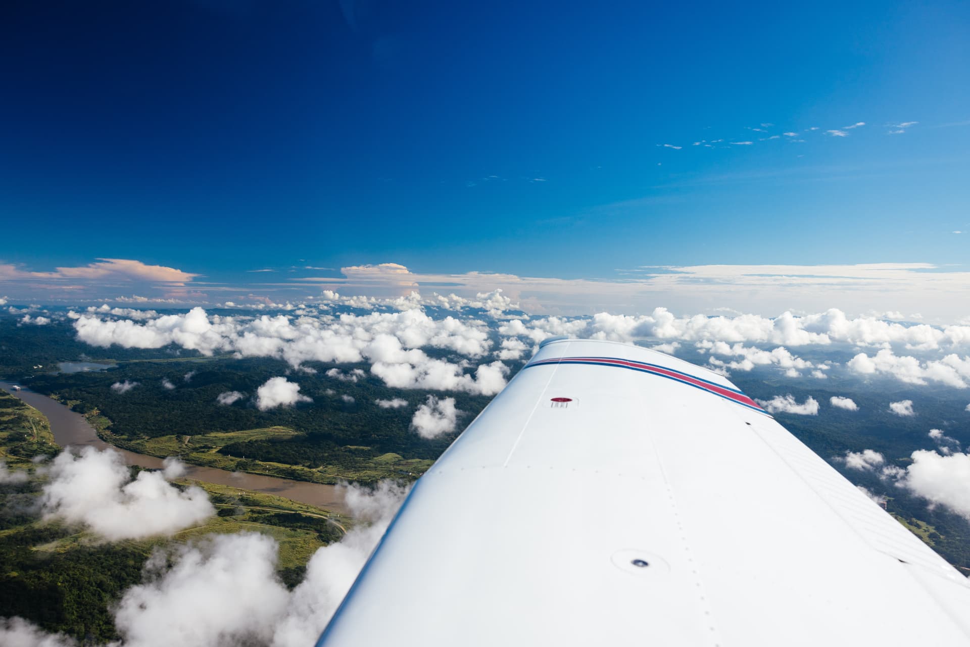 Ala de avión privado sobre nubes y selva panameña